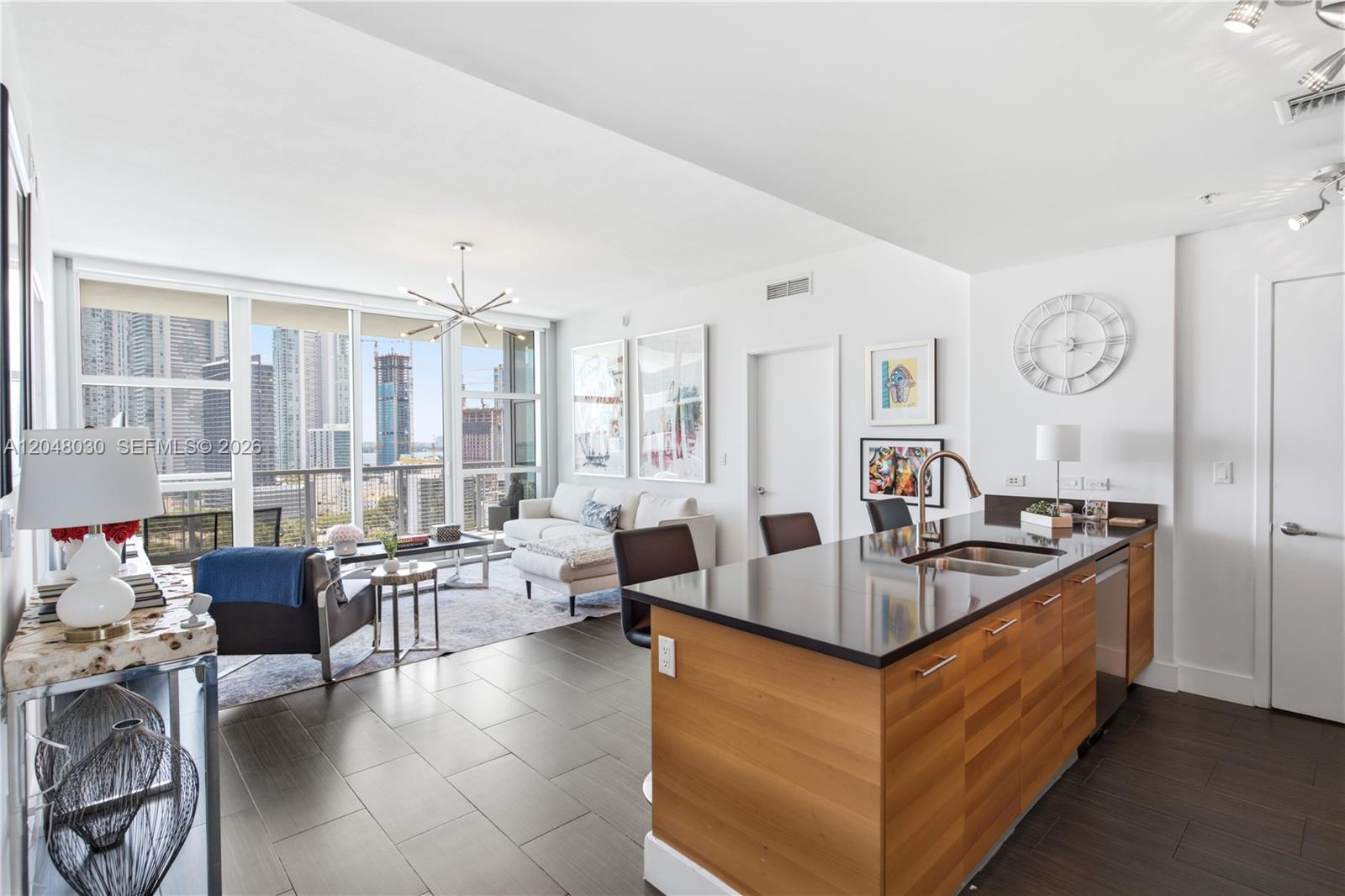 A modern apartment living area features a kitchen island, tile flooring, and floor-to-ceiling windows — 3301 NE 1st Ave # H1704, Miami FL 33137, MIAMI, FL