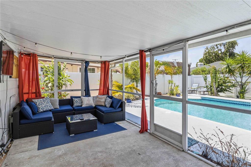 A screened-in patio features a blue sectional sofa, a coffee table, and a swimming pool — 2713 W BRADDOCK STREET, TAMPA, FL