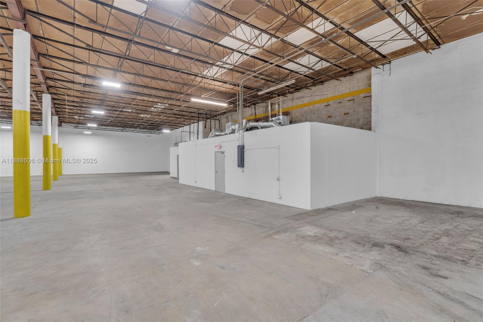 An empty industrial warehouse features concrete floors, exposed ceiling trusses, and a white partitioned office — 333 W 75th Pl # 1D, Hialeah FL 33014, HIALEAH, FL
