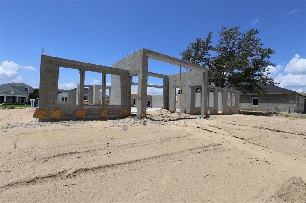 An unfinished room features concrete block walls with wood furring strips and exposed roof trusses — 3722 WOLVES CREEK PLACE, APOPKA, FL
