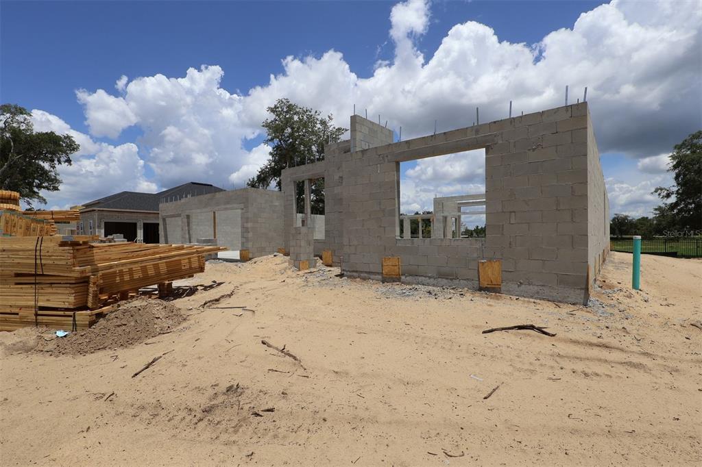 An interior view of a house under construction showing exposed wood framing and roof trusses — 3722 WOLVES CREEK PLACE, APOPKA, FL