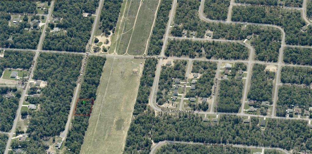 An aerial view shows a vacant, rectangular lot outlined in red along a paved road — 6925 N FOUNTAINHEAD DRIVE, CITRUS SPRINGS, FL