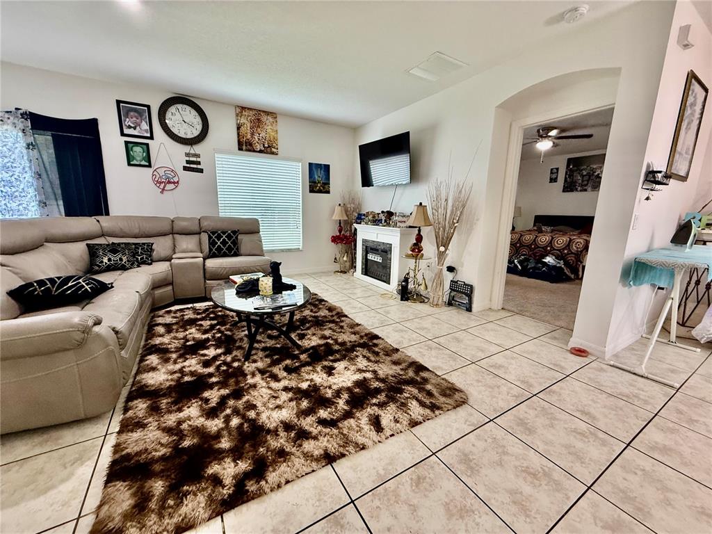 A living room features a large sectional sofa, a shag rug, and a fireplace — 4029 MARINA ISLE DRIVE, KISSIMMEE, FL