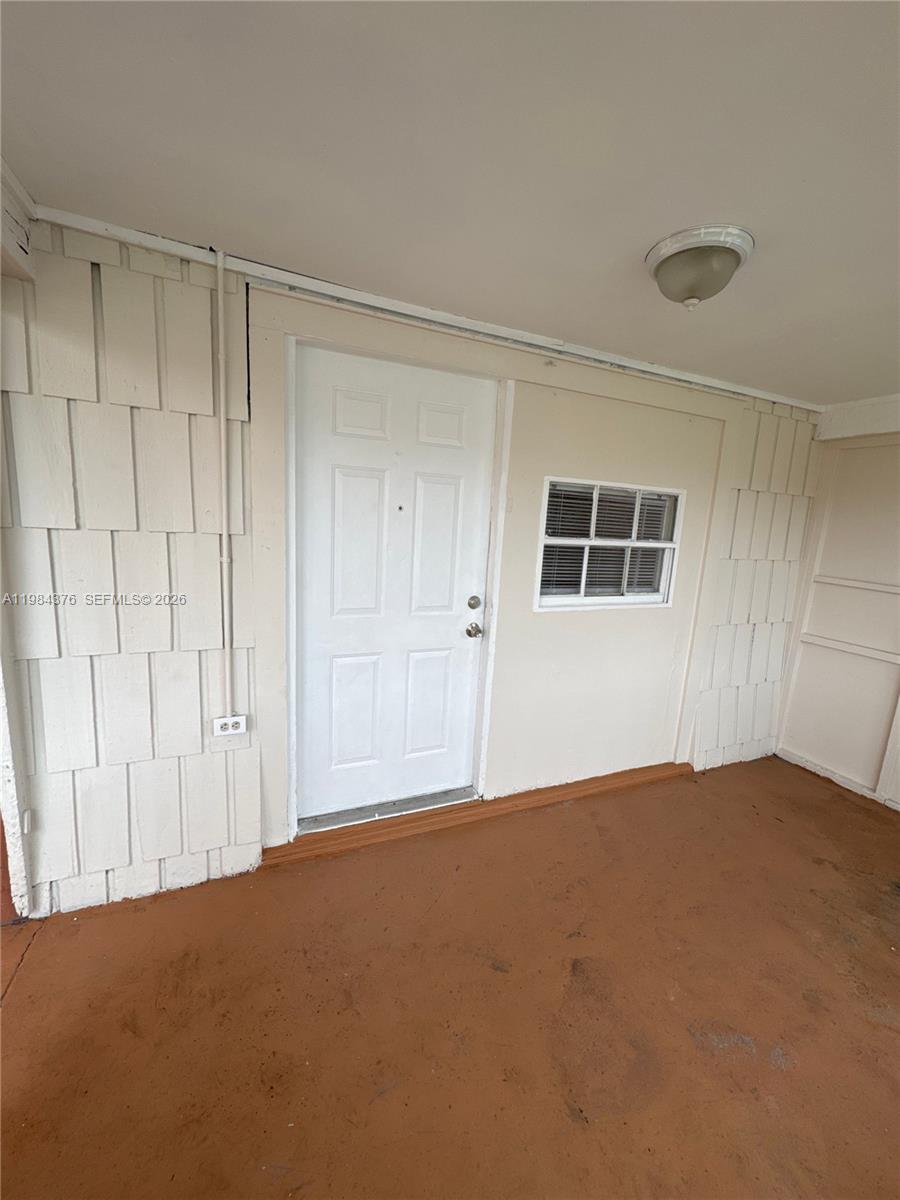 A covered porch features a white door, a small window, and light-colored shingle siding — 1545 NW 1st St # 1537, Miami FL 33125, MIAMI, FL