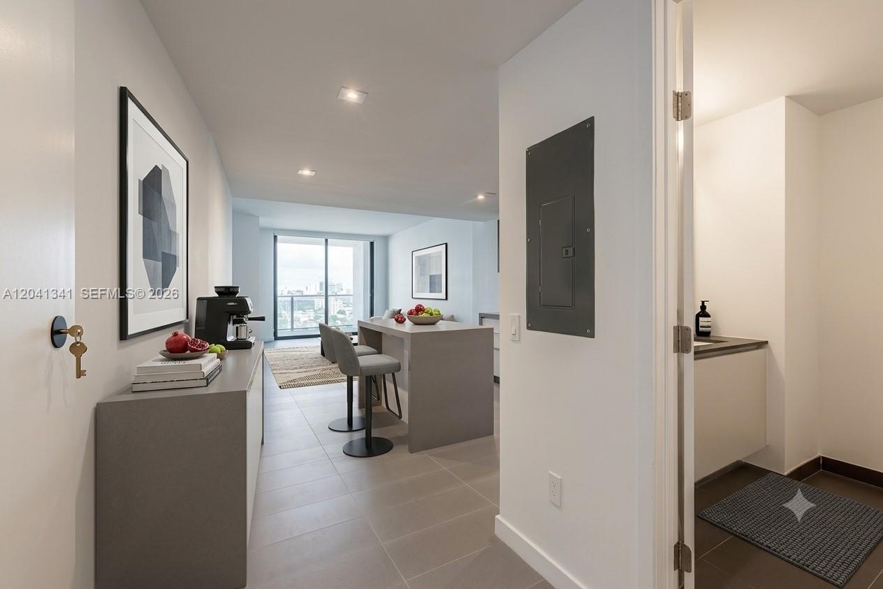 A modern apartment interior features a gray console table, kitchen island, and a small bathroom — 1600 NE 1st Ave # 1401, Miami FL 33132, MIAMI, FL