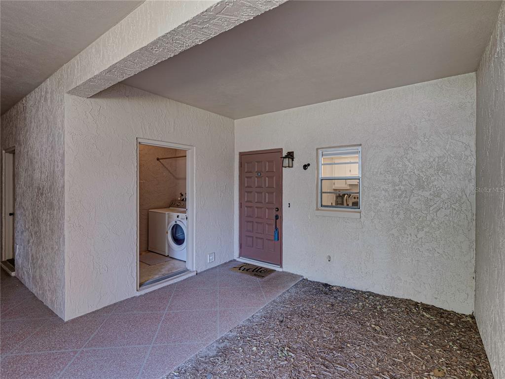 An exterior entryway features a brown door, a laundry closet, and a window — 9700 STARKEY ROAD UNIT 312, SEMINOLE, FL