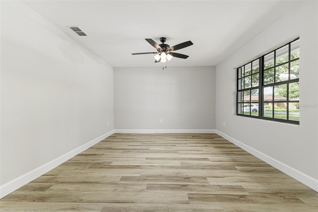A modern kitchen features white cabinets, quartz countertops, subway tile backsplash, and light wood flooring — 527 PRINCESS PLACE, LAKELAND, FL