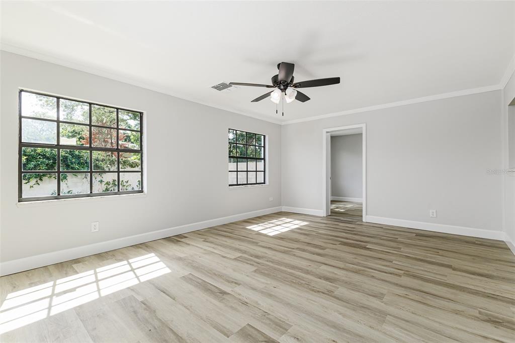 A kitchen with white cabinets and stainless steel appliances opens to a living area — 527 PRINCESS PLACE, LAKELAND, FL