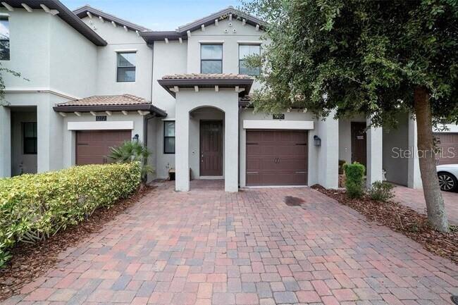An open-concept living and dining area features tile flooring, neutral furniture, and a modern chandelier — 1270 ROYAL ST GEORGE BOULEVARD, DAVENPORT, FL