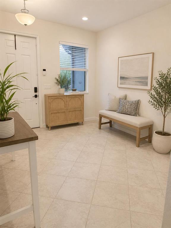 An entryway features a light-colored tile floor, a wooden cabinet, and a bench with pillows — 1270 ROYAL ST GEORGE BOULEVARD, DAVENPORT, FL