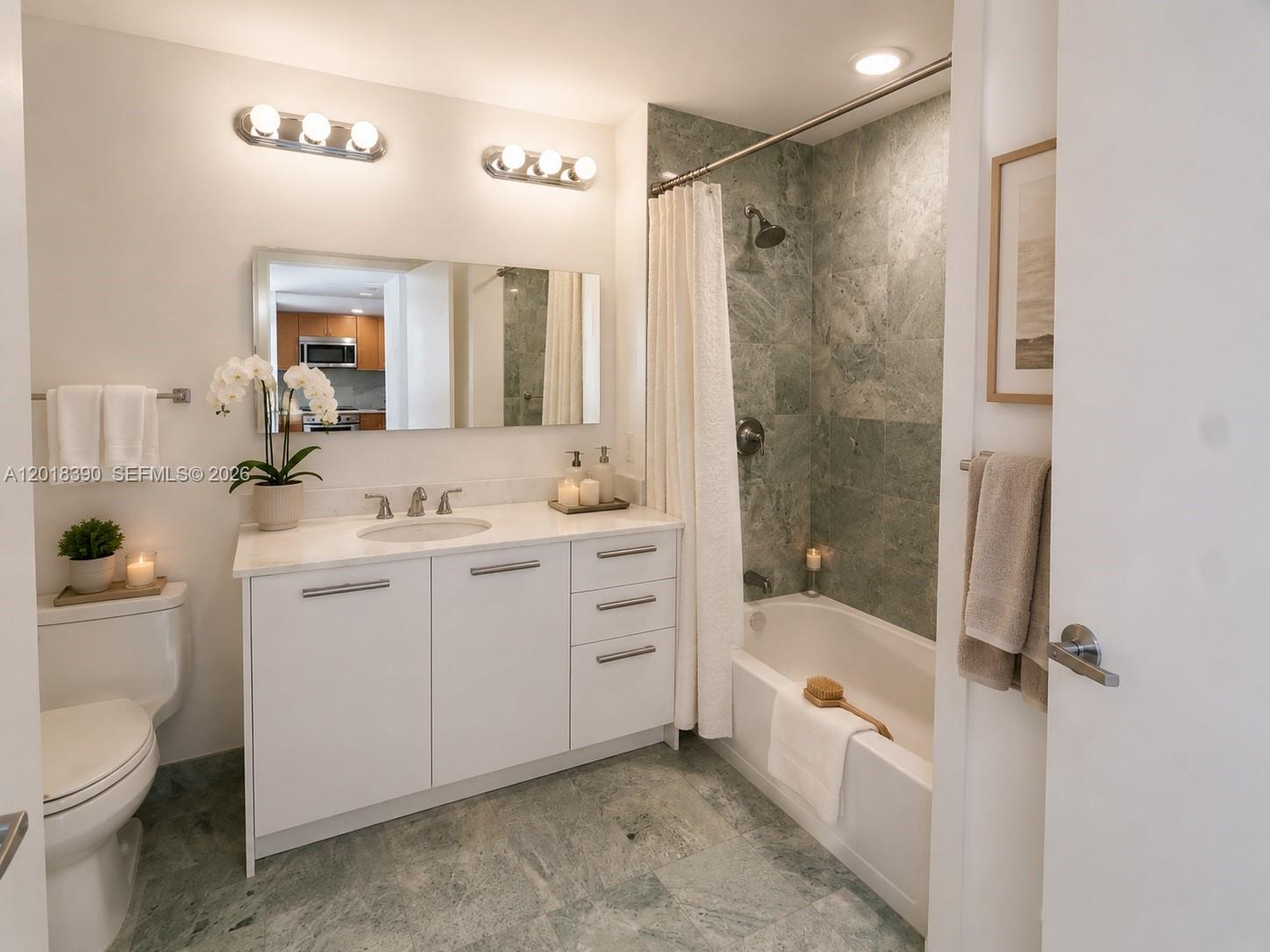 A bathroom features a white vanity, a green tiled shower-tub combination, and a toilet — 1050 Brickell Ave # 2706, Miami FL 33131, MIAMI, FL