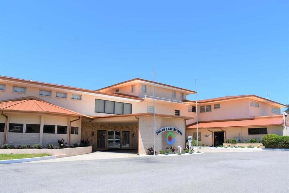 A multi-story building with a tan exterior, a stone-accented entrance, and a large parking lot — Tbd Azalea Drive, FL 33855, FL