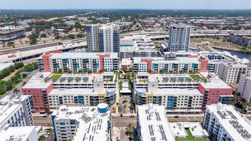 An aerial view shows several modern apartment complexes with rooftop pools and surrounding city streets — 1208 E KENNEDY BOULEVARD UNIT 831, TAMPA, FL