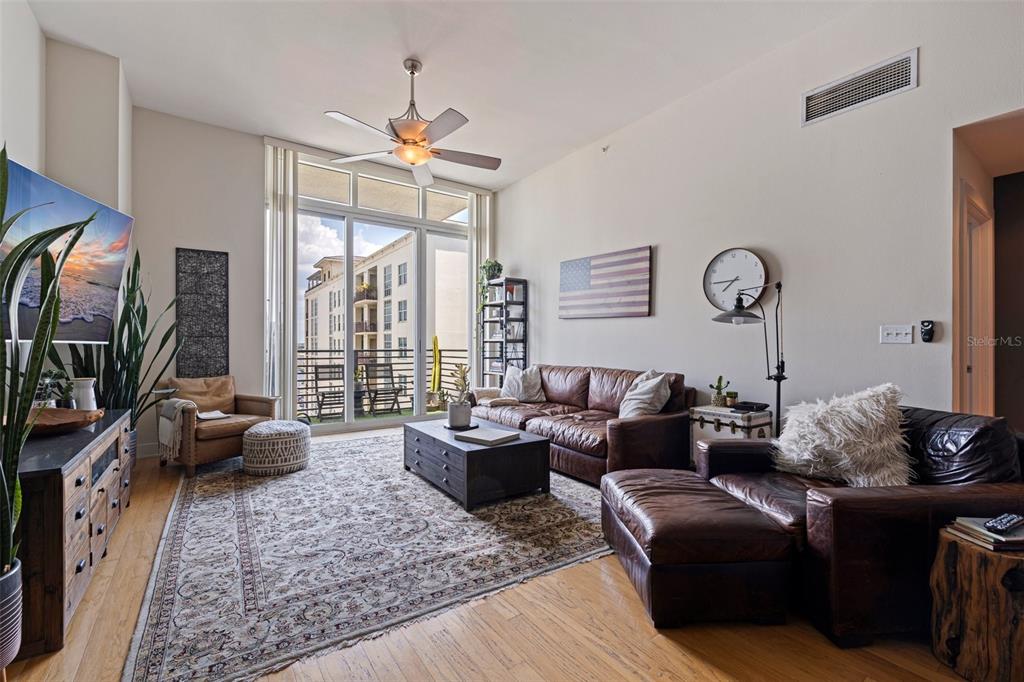 A living room features leather furniture, a patterned area rug, and a balcony with views — 1208 E KENNEDY BOULEVARD UNIT 831, TAMPA, FL