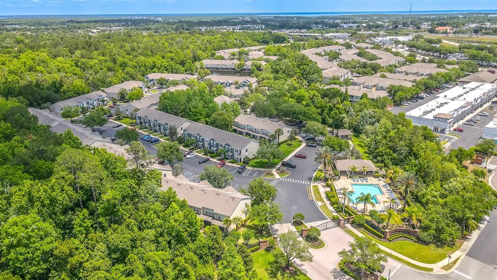 An aerial view of a residential apartment complex featuring a swimming pool and surrounding trees — 5338 HAWKSTONE DRIVE, SANFORD, FL