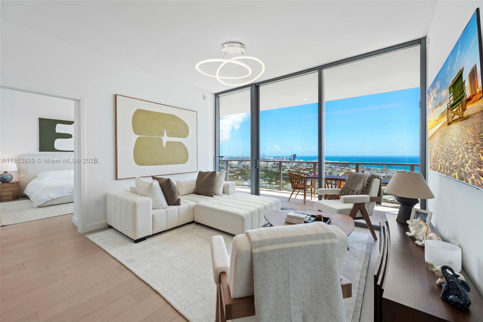 A modern living room features a white sectional sofa, floor-to-ceiling windows, and a balcony view — 500 alton  rd # 3604, Miami Beach FL 33139, MIAMI BEACH, FL
