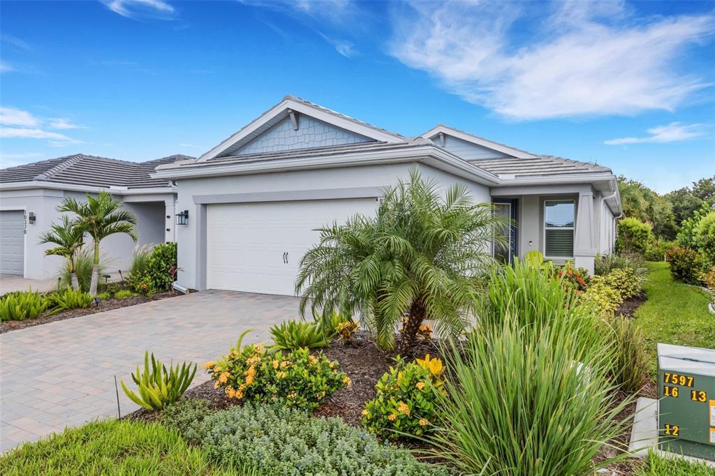 A single-story suburban house with a two-car garage, paved driveway, and landscaped front yard — 10374 ABACO FALLS DRIVE, ENGLEWOOD, FL