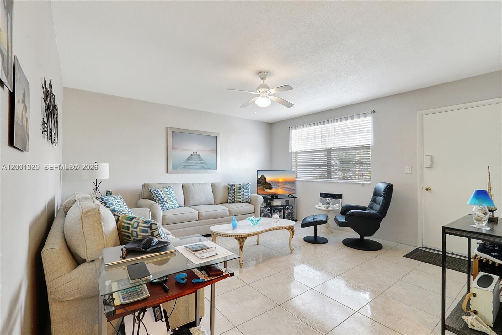 A living room features a beige sofa, a glass coffee table, and a black recliner — 16801 NE 13th Ave # 206, Miami FL 33162, MIAMI, FL