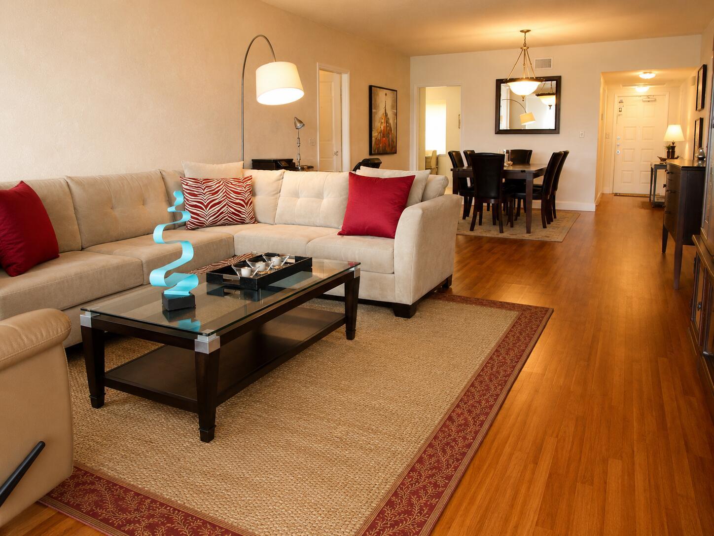 A living room with a beige sectional, glass coffee table, and adjacent dining area — 804 Cypress Boulevard # 104, Pompano Beach FL 33069, POMPANO BEACH, FL