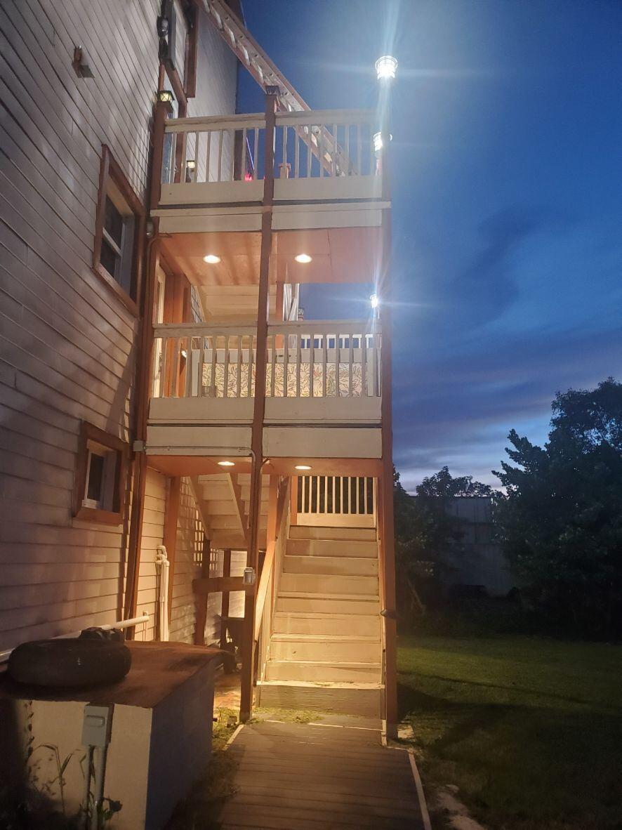 A multi-story wooden exterior staircase and balcony structure attached to the side of a house — 16825 89th Place N, FL 33470, FL
