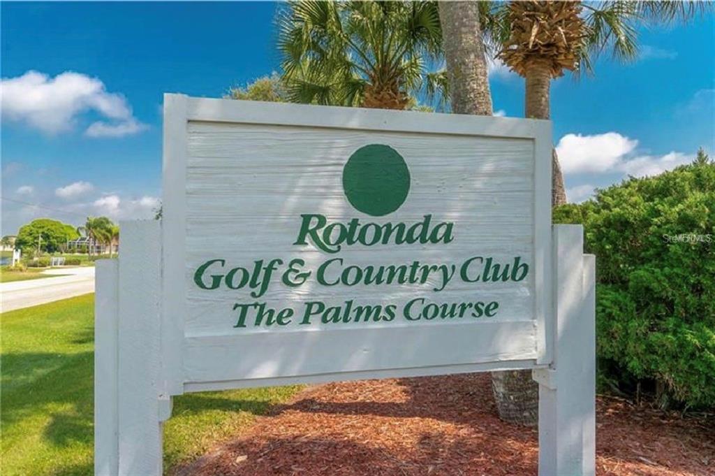 A white sign for the Rotonda Golf & Country Club stands outdoors near palm trees — 113 WHITE MARSH LANE, ROTONDA WEST, FL