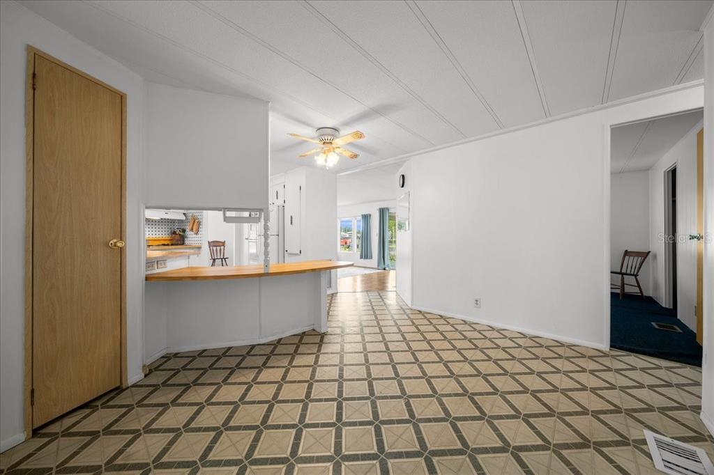 A dining area with patterned tile floors, a breakfast bar, and a ceiling fan — 3221 SE 39TH AVENUE, OCALA, FL