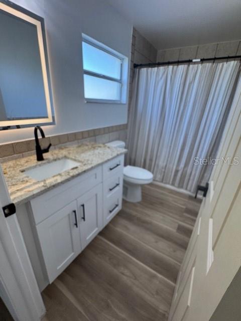 A bathroom features a white vanity with a granite countertop, a mirror, and a shower — 420 ALBATROSS COURT, KISSIMMEE, FL