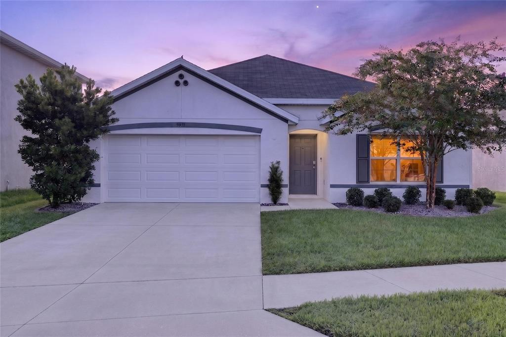 A single-story house with a white stucco exterior, a two-car garage, and a front lawn — 5491 SW 43RD COURT, OCALA, FL