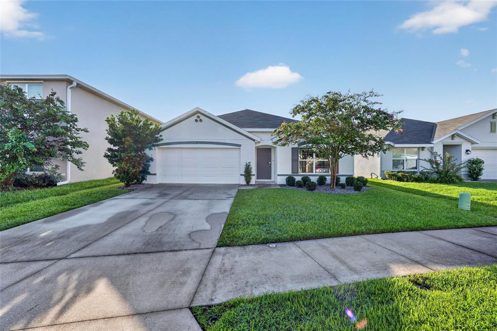 A single-story suburban house with a white stucco exterior, a two-car garage, and a lawn — 5491 SW 43RD COURT, OCALA, FL