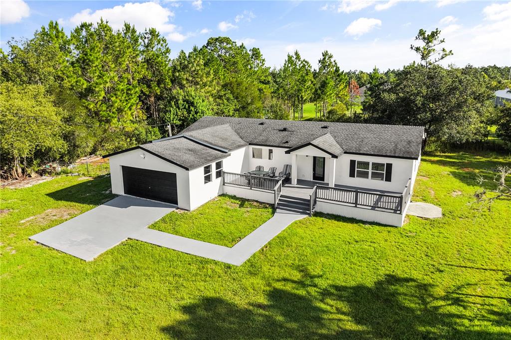 An aerial view of a white single-story house with a black roof and garage — 19413 OBERLY PARKWAY, ORLANDO, FL