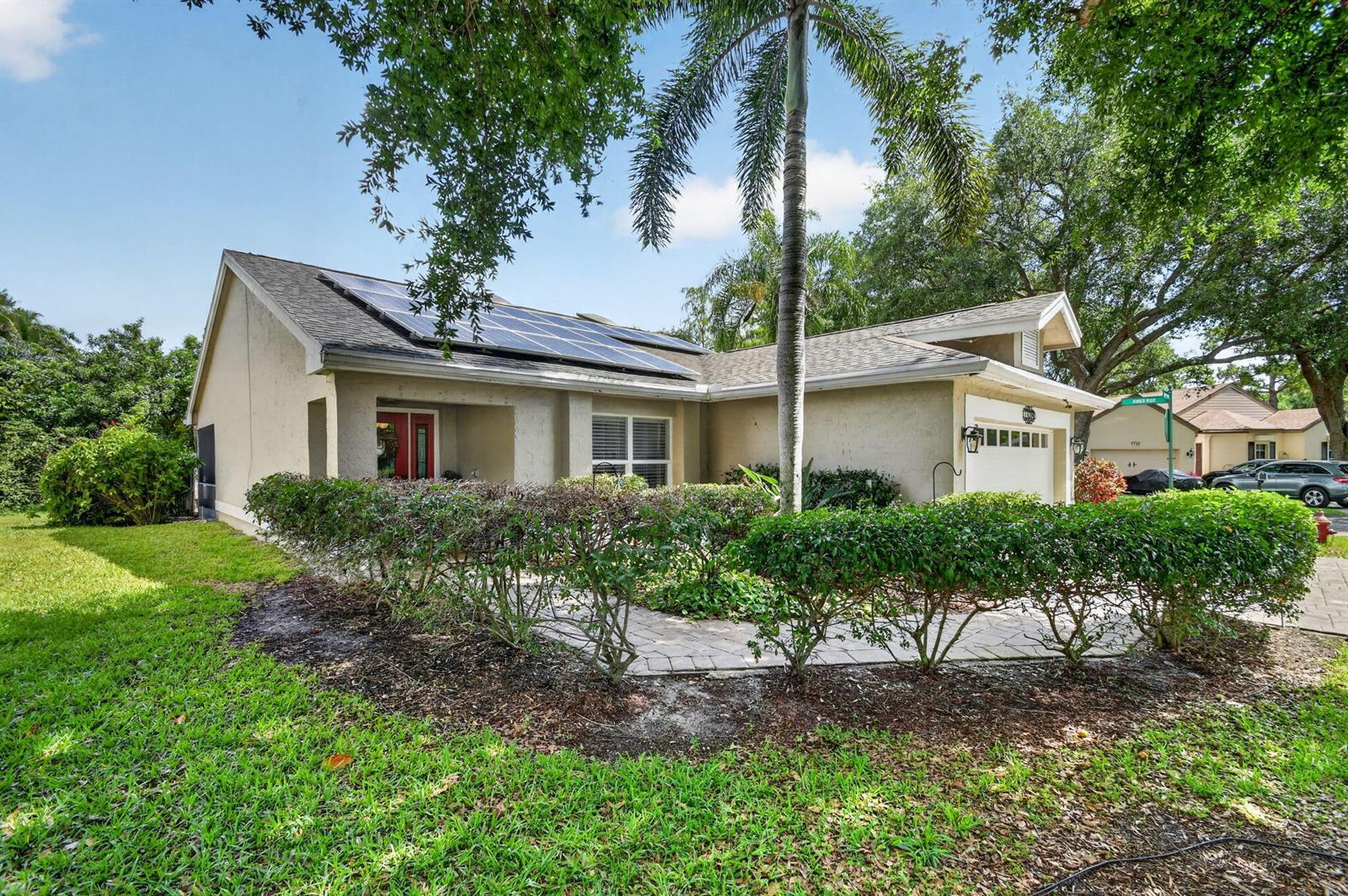 A single-story house with solar panels on the roof, a paved walkway, and landscaping — 4200 Grove Park Lane, Boynton Beach FL 33436, BOYNTON BEACH, FL