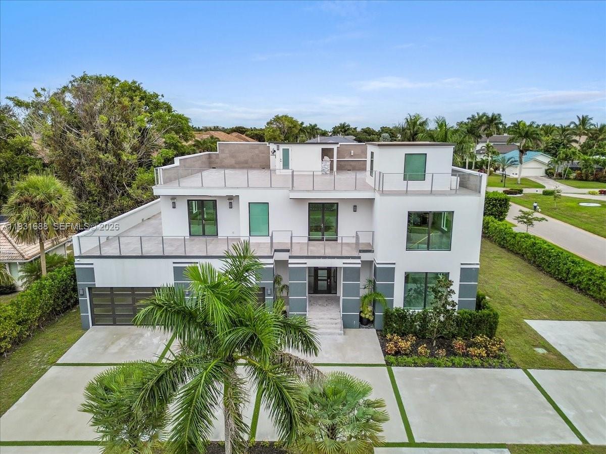 An aerial view of a modern three-story white house with balconies and a flat roof — 3800 Crayton Road, Naples FL 34103, NAPLES, FL