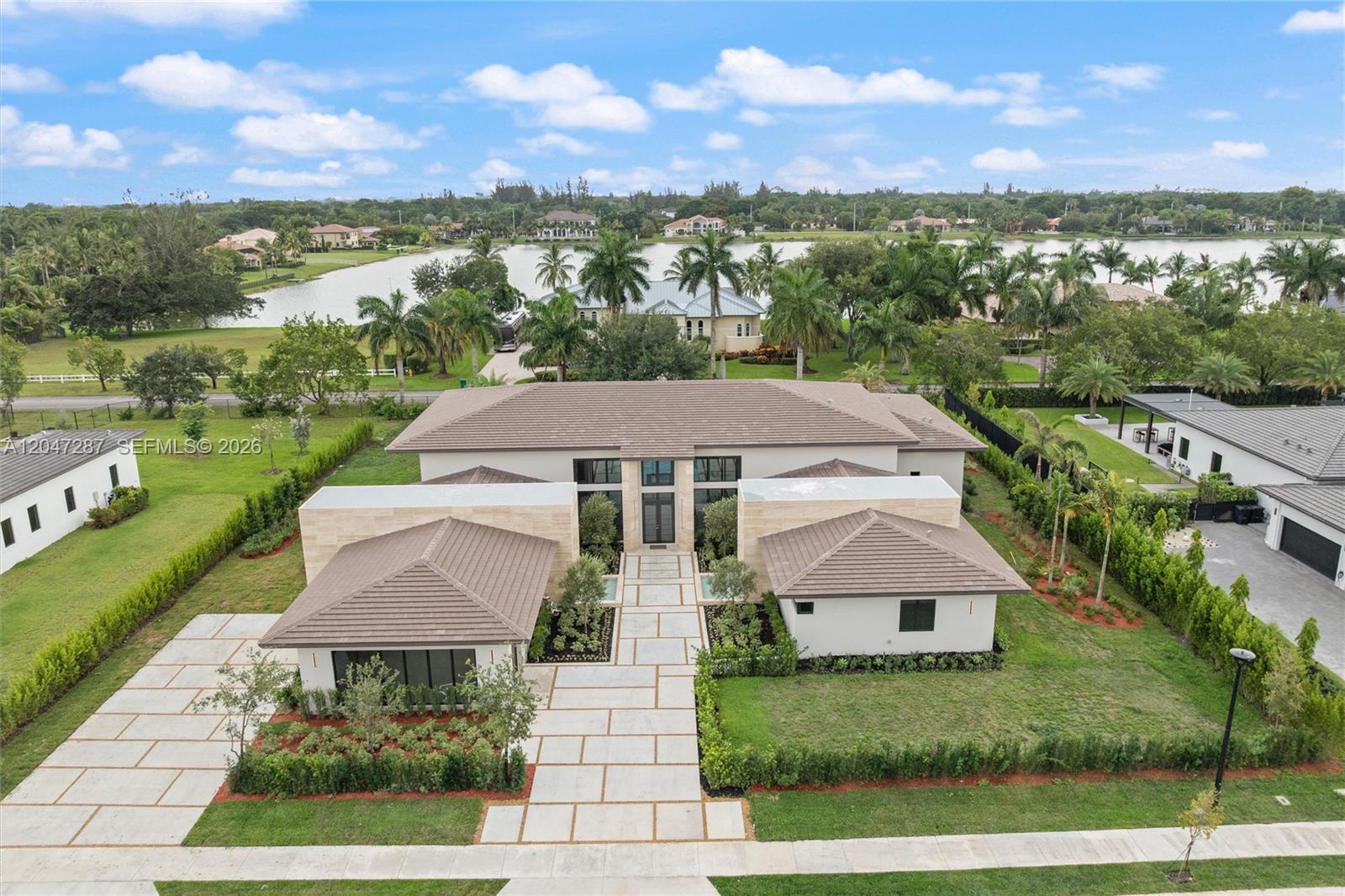 An aerial view shows a modern single-story house with a tiled roof and stone facade — 14930 SW 16th Ct, Davie FL 33326, DAVIE, FL