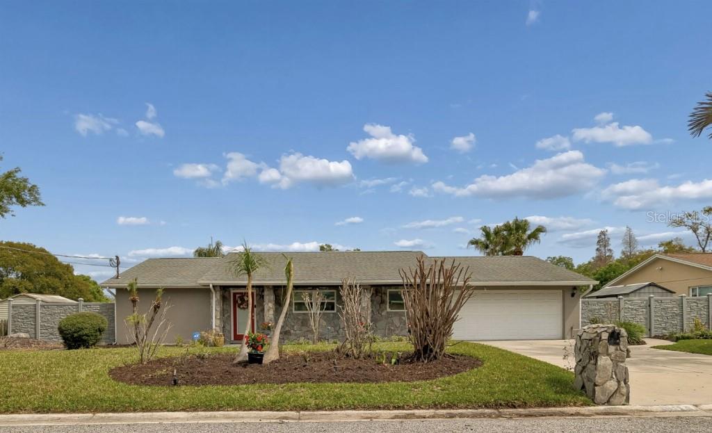 A single-story ranch house with a stone facade, a two-car garage, and a landscaped yard — 1611 SUNNYHILLS DRIVE, BRANDON, FL