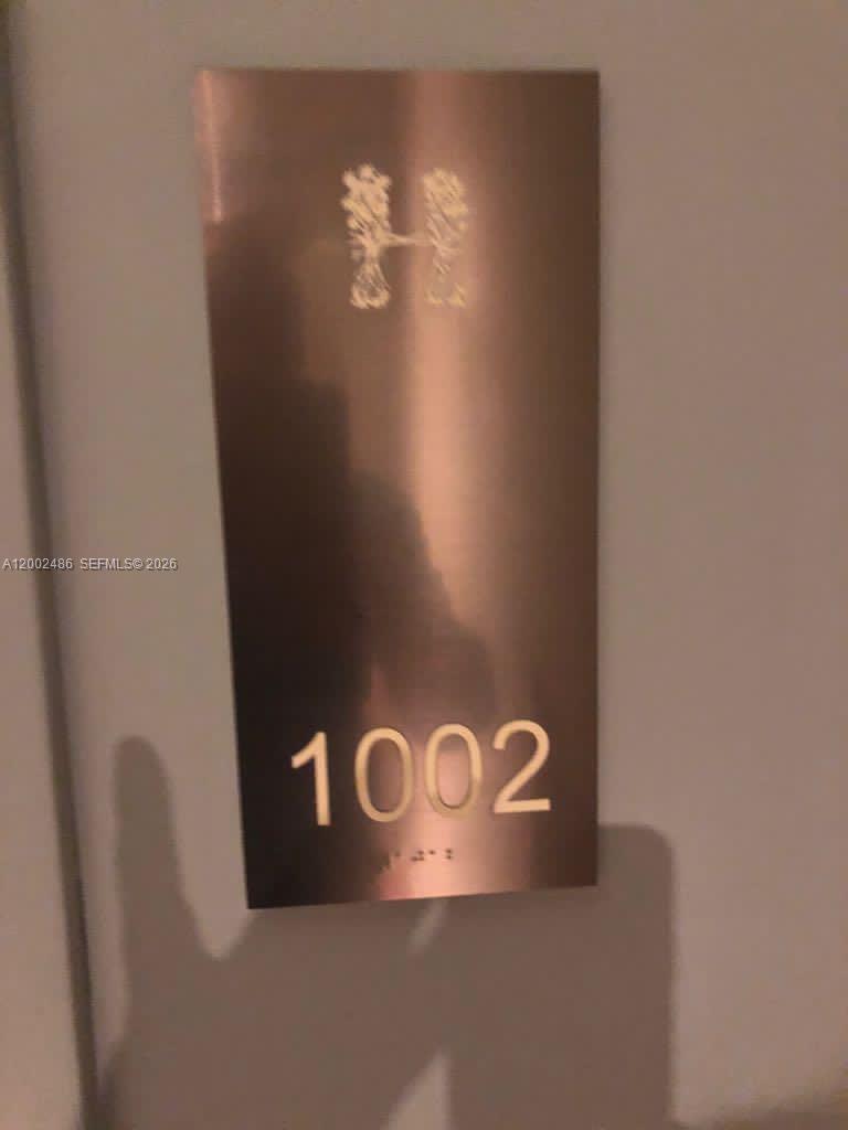 A metallic door sign displays the letter H and the number 1002 with braille — 4111 S Ocean Dr # 1002, Hollywood FL 33019, HOLLYWOOD, FL