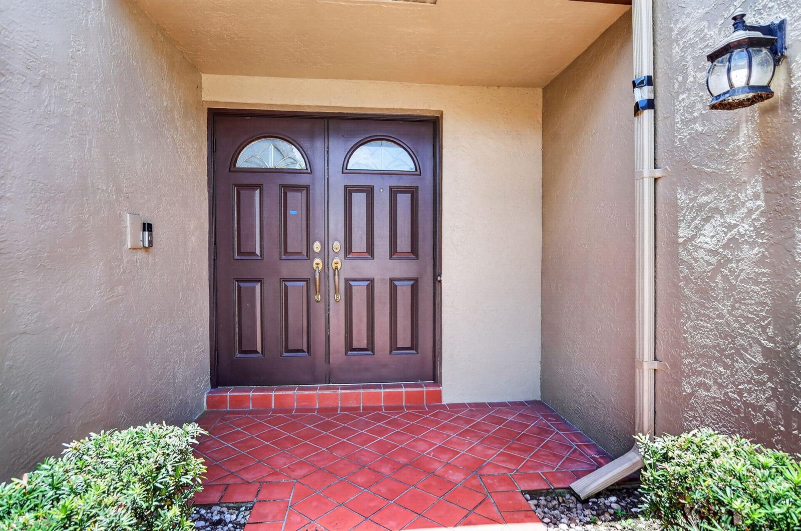 A front entrance features double brown doors with arched windows and red tile flooring — 7690 Solimar Circle, Boca Raton FL 33433, BOCA RATON, FL