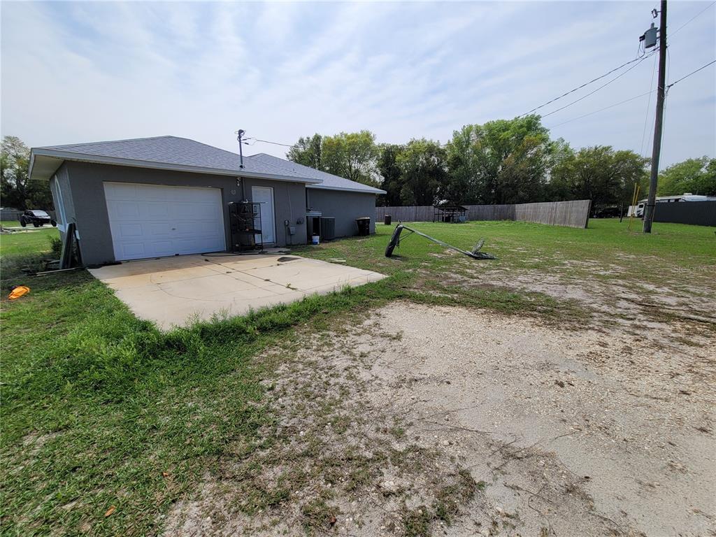 A gray house with a garage, concrete driveway, and a large, grassy backyard — 425 STOKES RD, LAKE WALES, FL