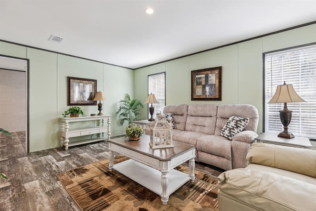 A living room features light green walls, wood-look flooring, a beige sofa, and a coffee table — TBD NE 122ND AVENUE, WILLISTON, FL
