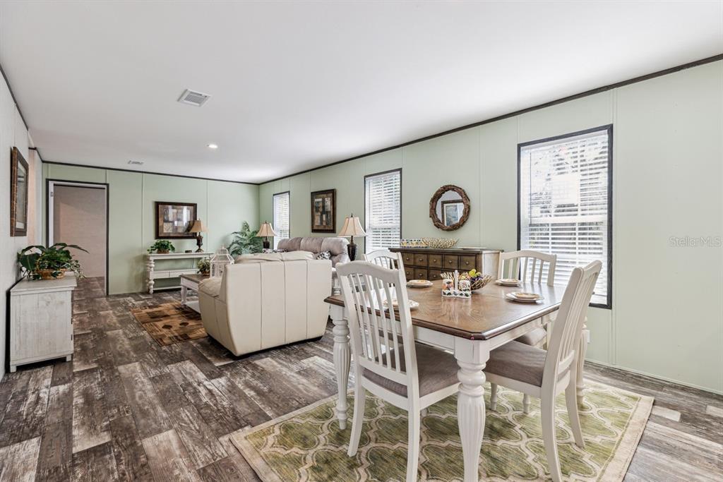 A dining area and living room with light green walls and wood-look flooring — TBD NE 122ND AVENUE, WILLISTON, FL