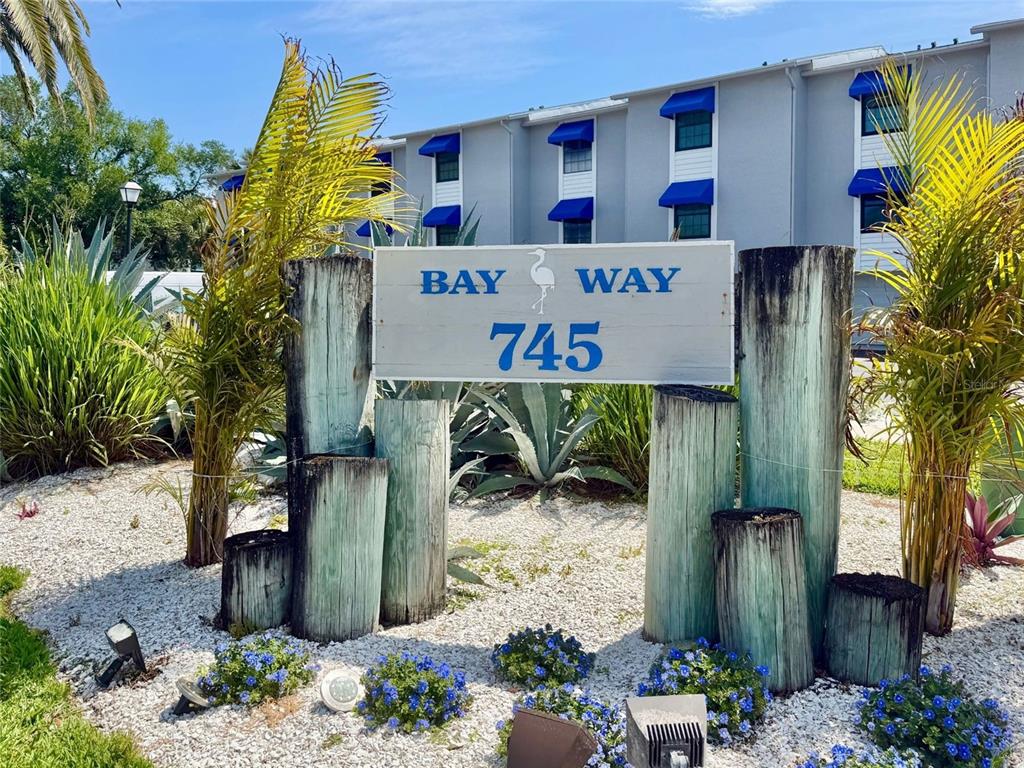 A sign reading Bay Way 745 stands in front of a multi-story apartment building — 745 PINELLAS BAYWAY S UNIT 202, TIERRA VERDE, FL