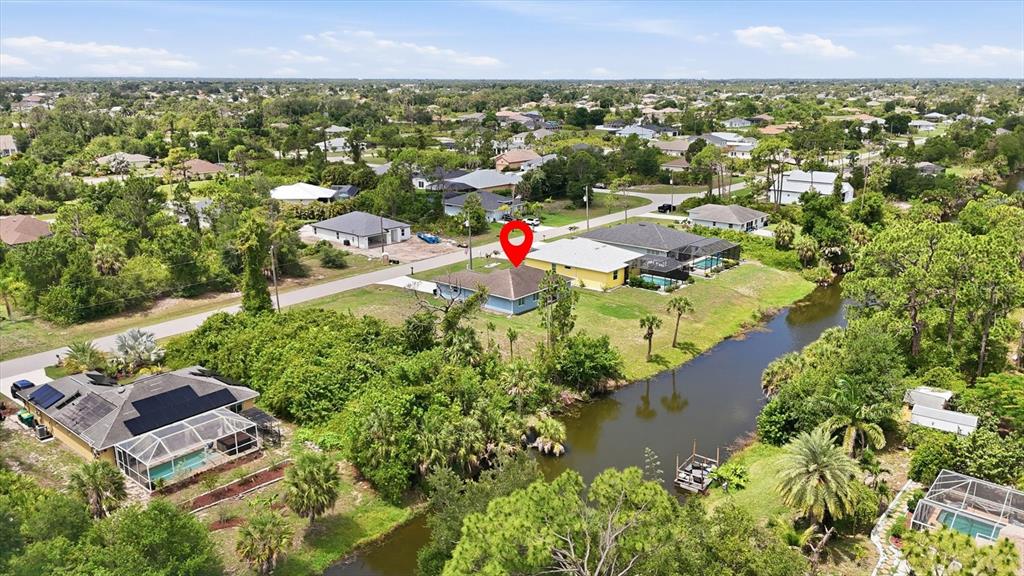 An aerial view shows a blue house with a red location pin near a canal — 150 BAYTREE DRIVE, ROTONDA WEST, FL