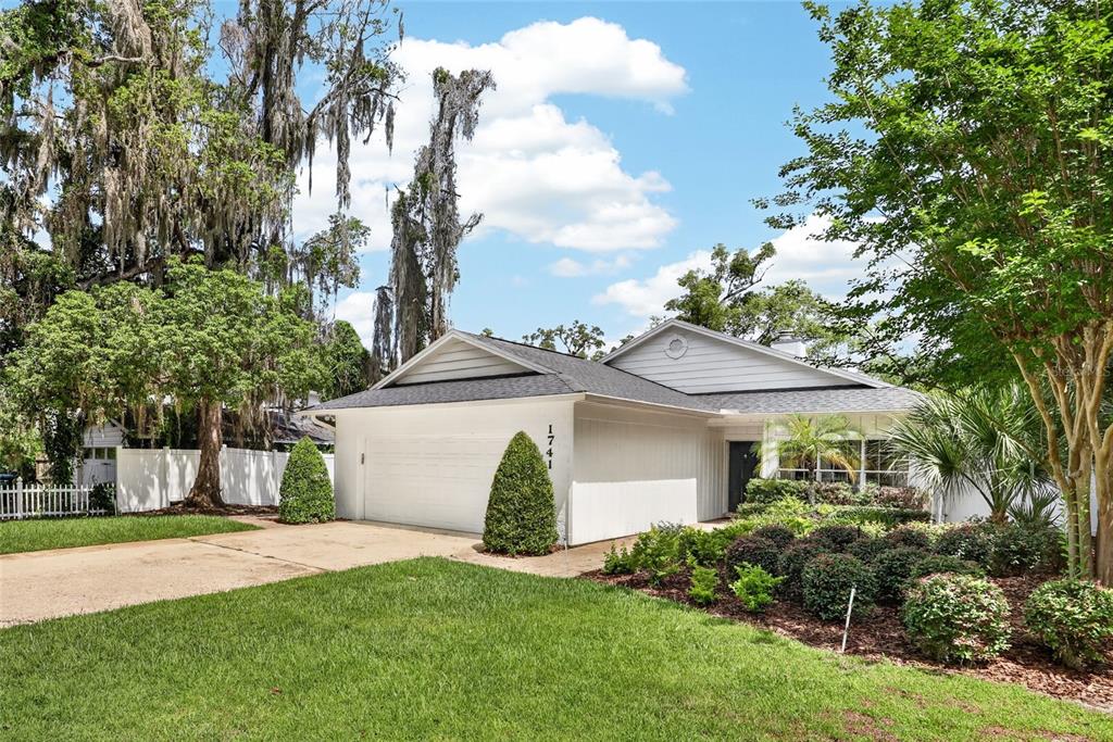A single-story house with a white exterior, a two-car garage, and a landscaped front yard — 1741 MIZELL AVENUE, WINTER PARK, FL