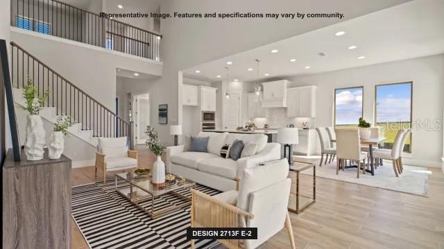 This is a rendering of an open-concept living room and kitchen with a staircase — 13062 CAMELOT LANE, PUNTA GORDA, FL