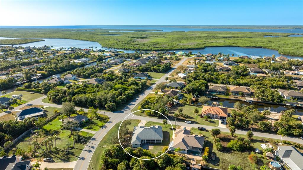An aerial view shows a single-story house with a gray roof in a residential neighborhood — 17220 HORIZON LANE, PORT CHARLOTTE, FL