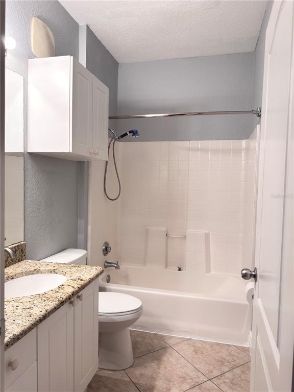 A bathroom features a granite-topped vanity, a white toilet, and a tub-shower combination — 2715 VIA CAPRI UNIT 728, CLEARWATER, FL