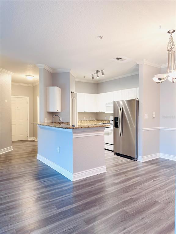 A kitchen with white cabinets, stainless steel appliances, and a granite-topped island — 2715 VIA CAPRI UNIT 728, CLEARWATER, FL