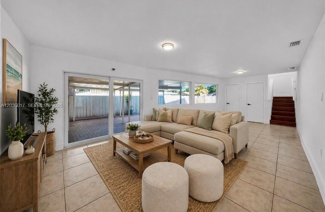 A living room features a beige sectional sofa, a wooden coffee table, and tile flooring — 8241 SW 12th Ter, Miami FL 33144, MIAMI, FL