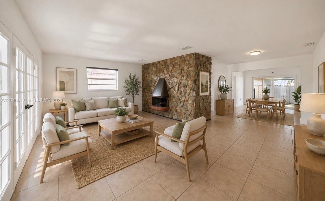 A living room features a stone fireplace, tile flooring, and a dining area in the background — 8241 SW 12th Ter, Miami FL 33144, MIAMI, FL