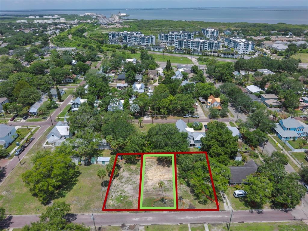 An aerial view shows a vacant, rectangular lot outlined in green among surrounding residential properties — 6907 S SPARKMAN STREET, TAMPA, FL