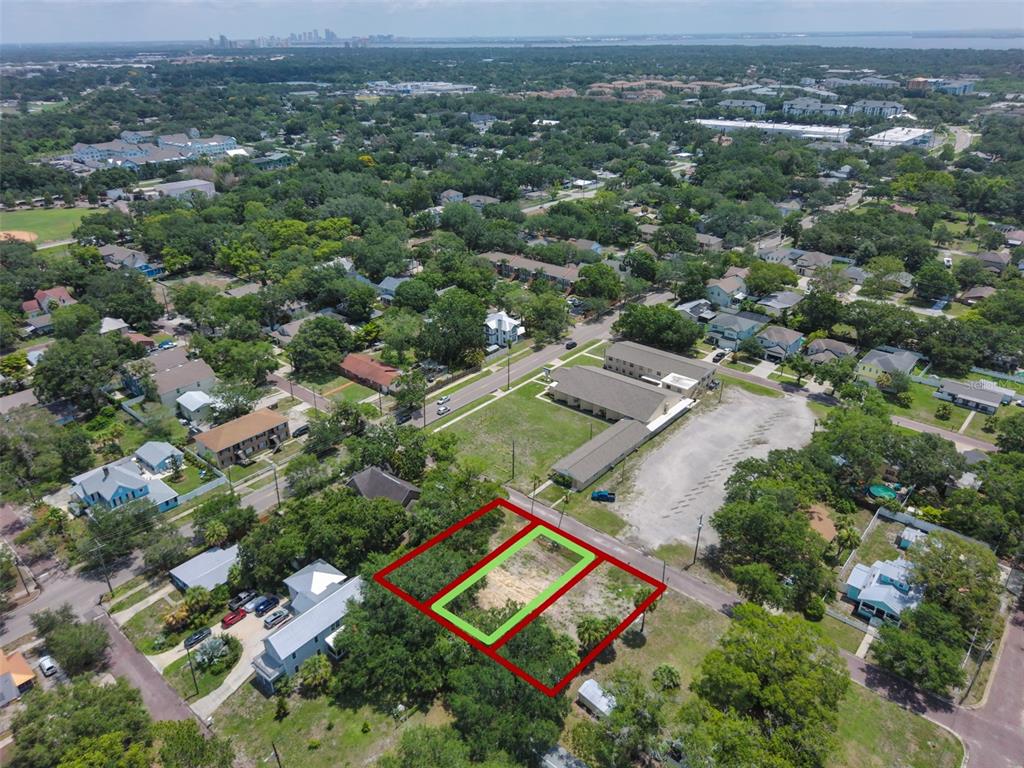 An aerial view shows a vacant lot outlined in red and green within a residential neighborhood — 6907 S SPARKMAN STREET, TAMPA, FL